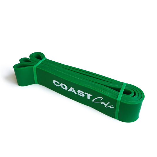 A rolled up green exercise band with the brand name 'COAST Cali' printed on it.
