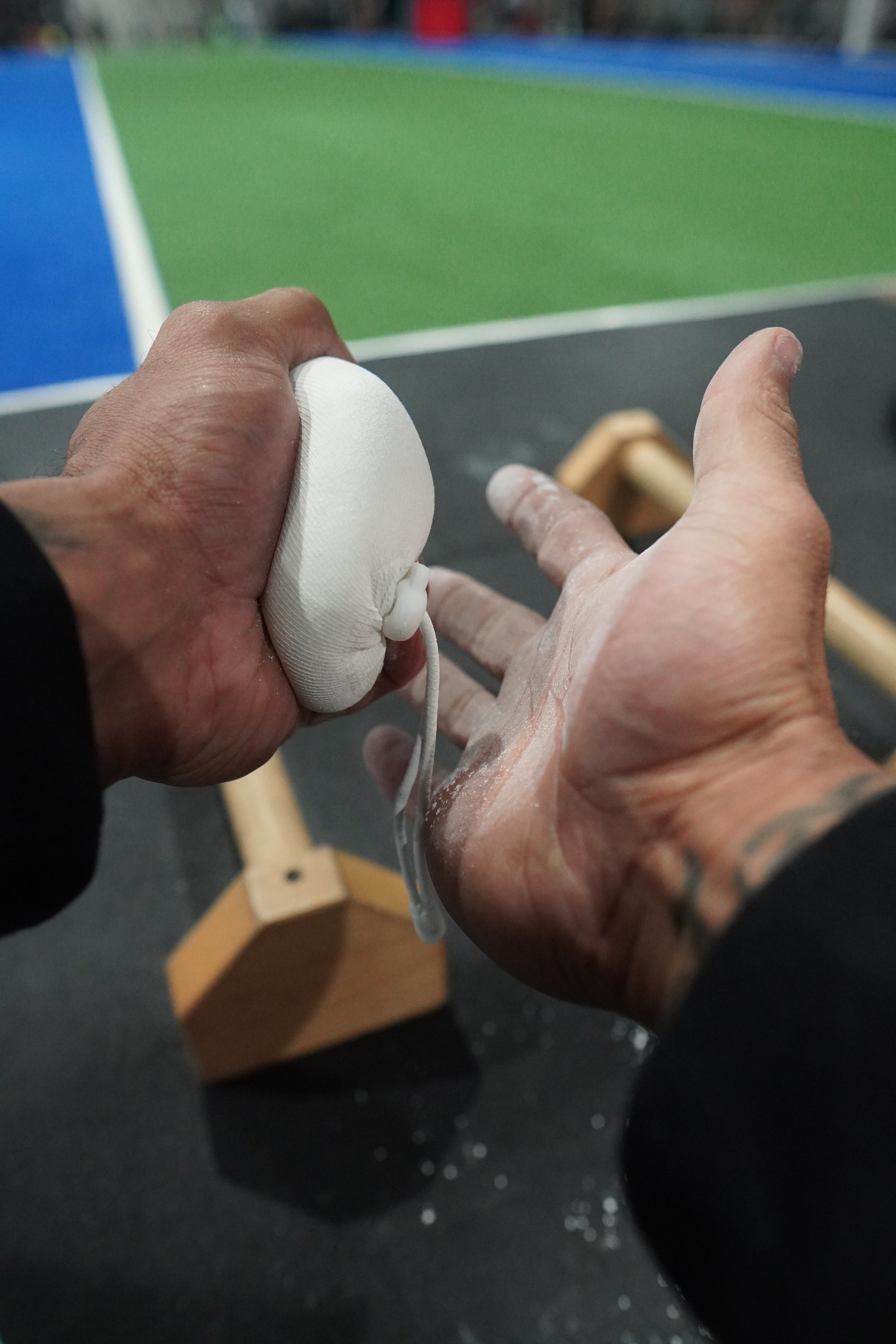 A close up of chalk on hands in a gym environment