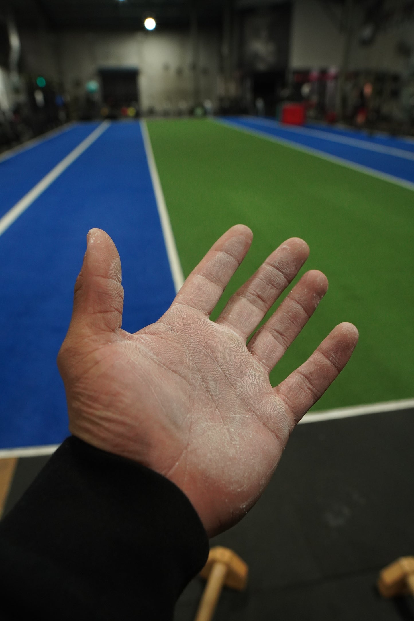 A close up of a hand with chalk on it in a gym from a chalk ball