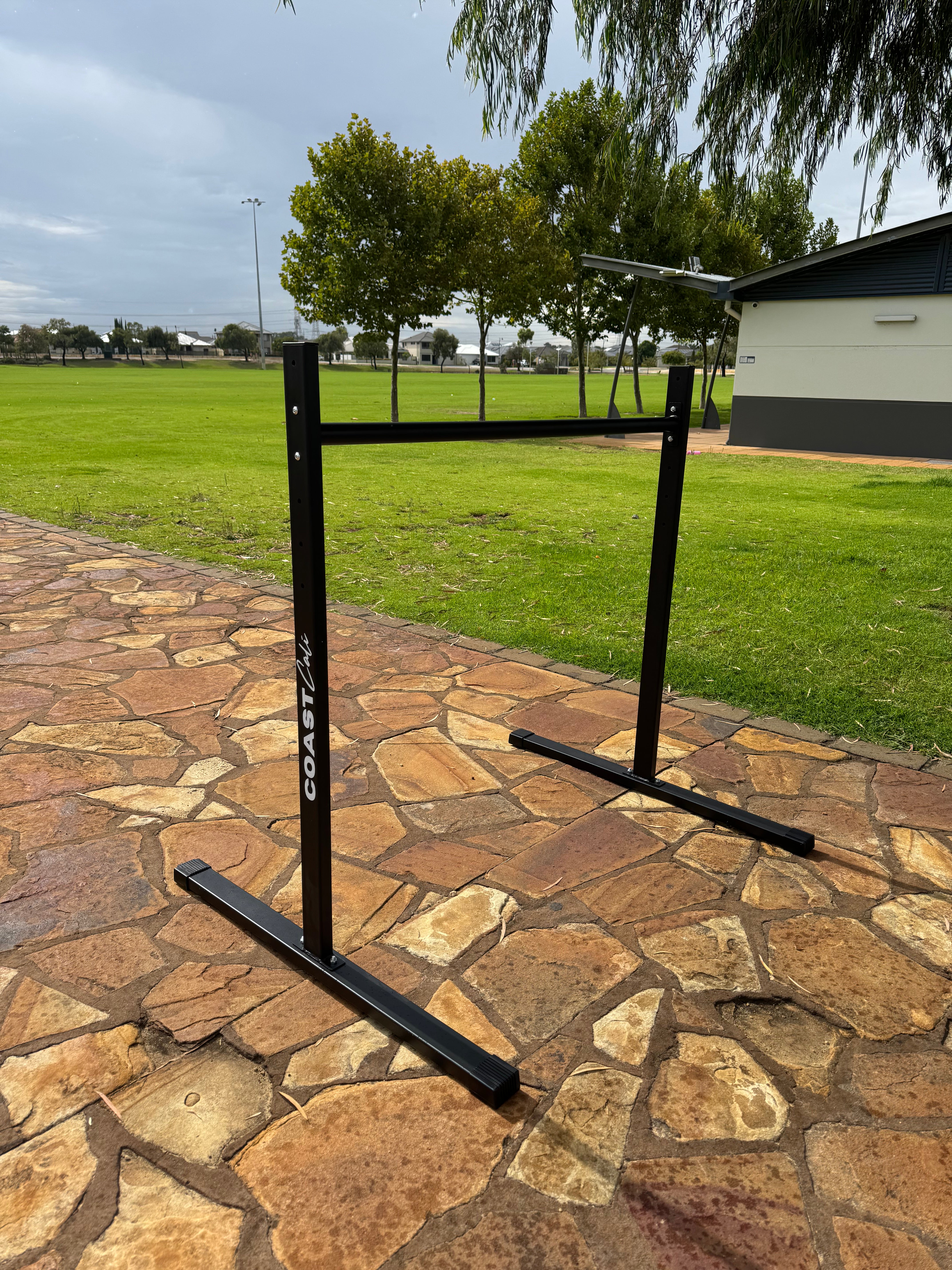 A black static bar used for calisthenics with Coast Cali logo on the vertical support.