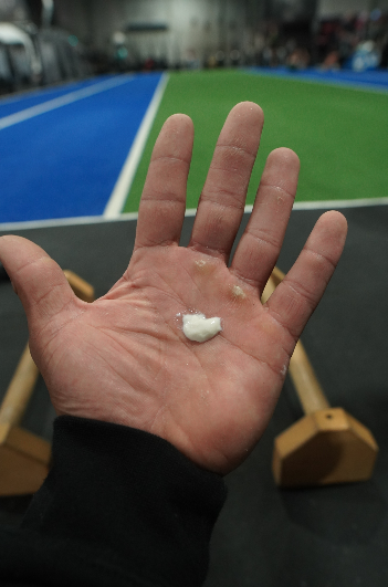 A blob of liquid chalk on the palm of a hand in the gym