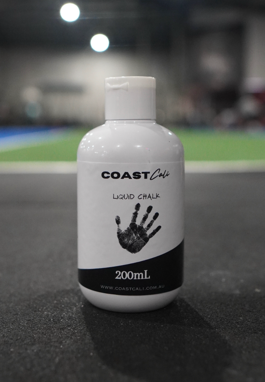 A close up of a 200ml liquid chalk with a gym in the background