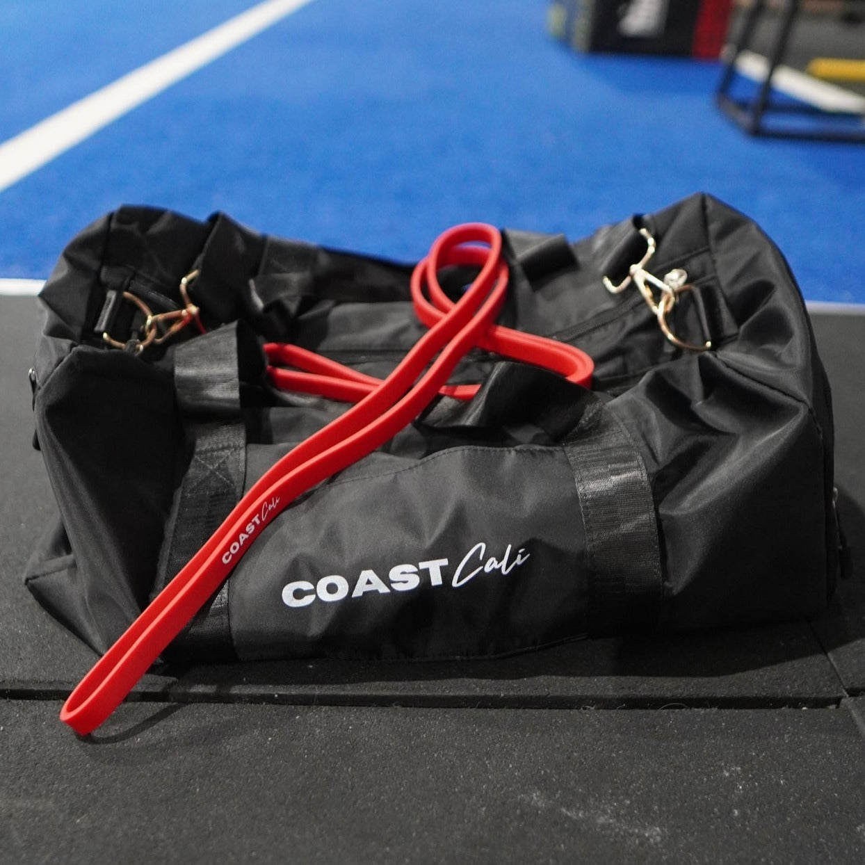 A red resistance band on a black duffle bag