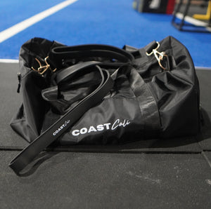 A black resistance band on a black duffle bag