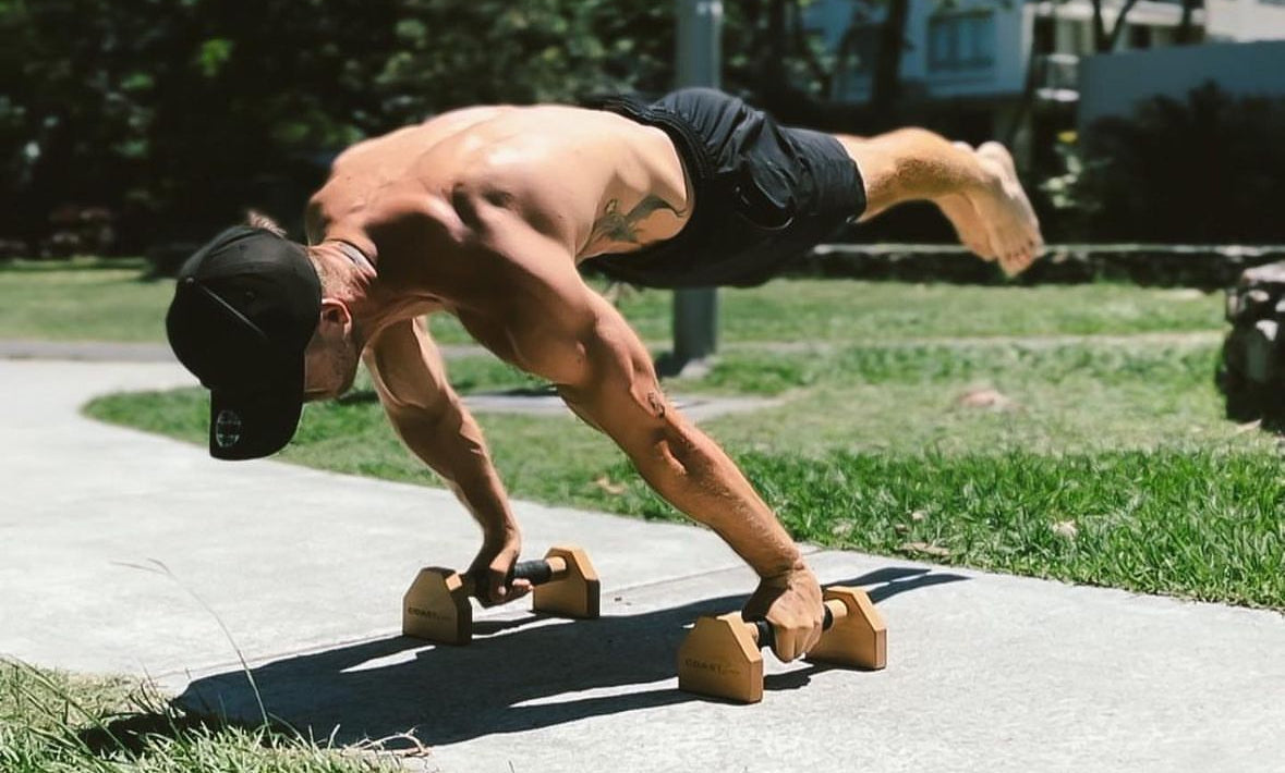 Man holding a planche on Coast Cali wooden parallettes