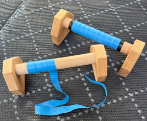 A pair of 30cm calisthenics parallettes with semi wrapped blue grip tape