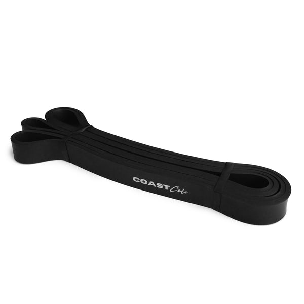 A rolled up black exercise band with the text 'COAST fit' visible on it, indicating the brand.