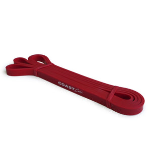 A rolled up red exercise band with the text 'COAST cali' visible on it, against a white background.