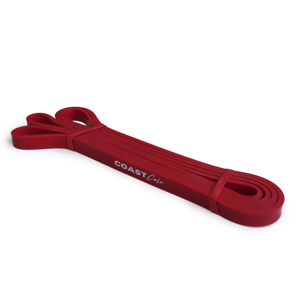 A rolled up red exercise band with the text 'COAST cali' visible on it, against a white background.