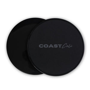 Two black gymnastics sliders with the logo 'COAST Cali' on the top surface.