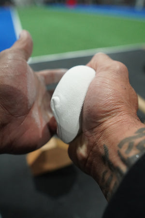 A close of of some hands applying chalk via a chalk ball