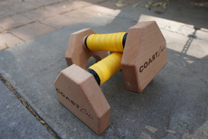 A pair of parallettes with yellow grip tape