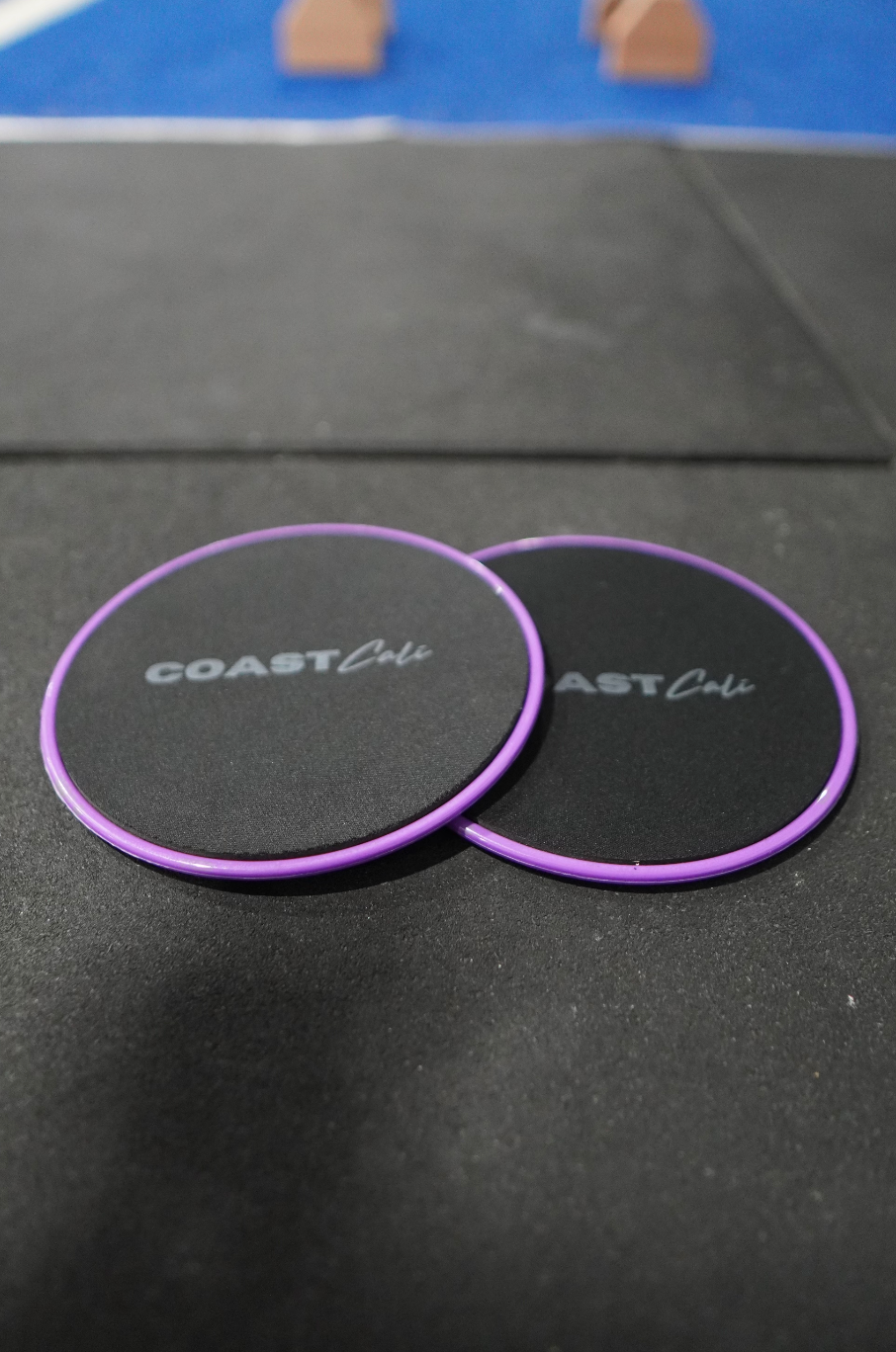 Two purple gymnastics sliders with the logo 'COAST Cali' on the top surface.